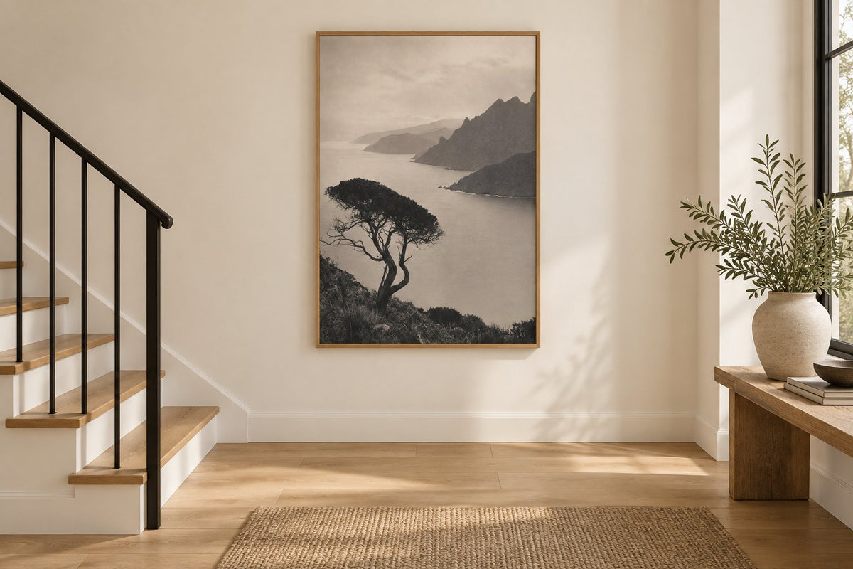 Interieursimulatie van een trap met een poster van de Corsicaanse kust in een eiken lijst op de overloop