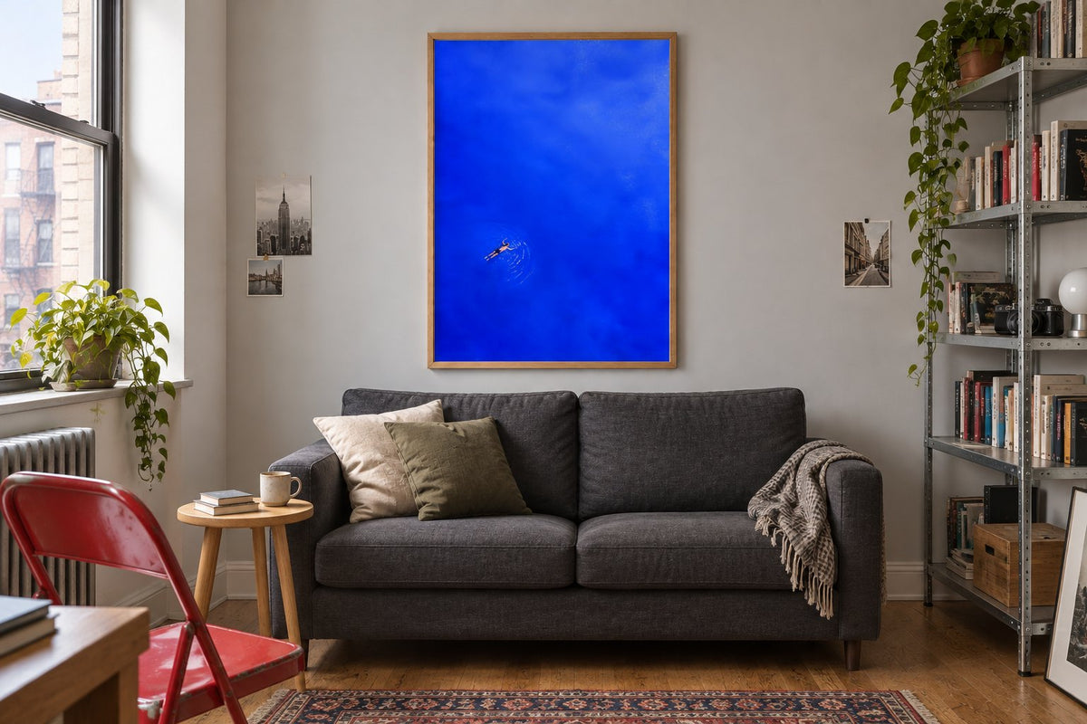 Room visualisation of a small living room with a blue swimmer print in an oak frame