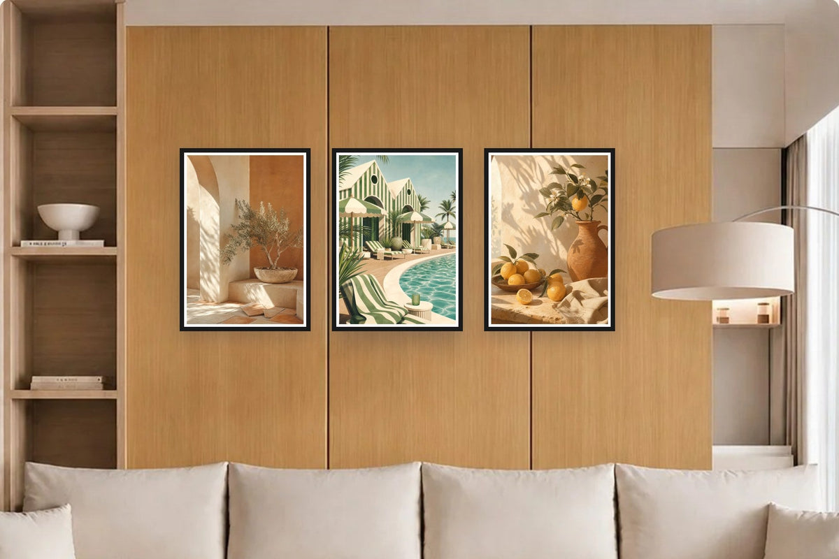 Trois affiches en cadres noirs sur un mur ocre, au-dessus d'un canapé écru.