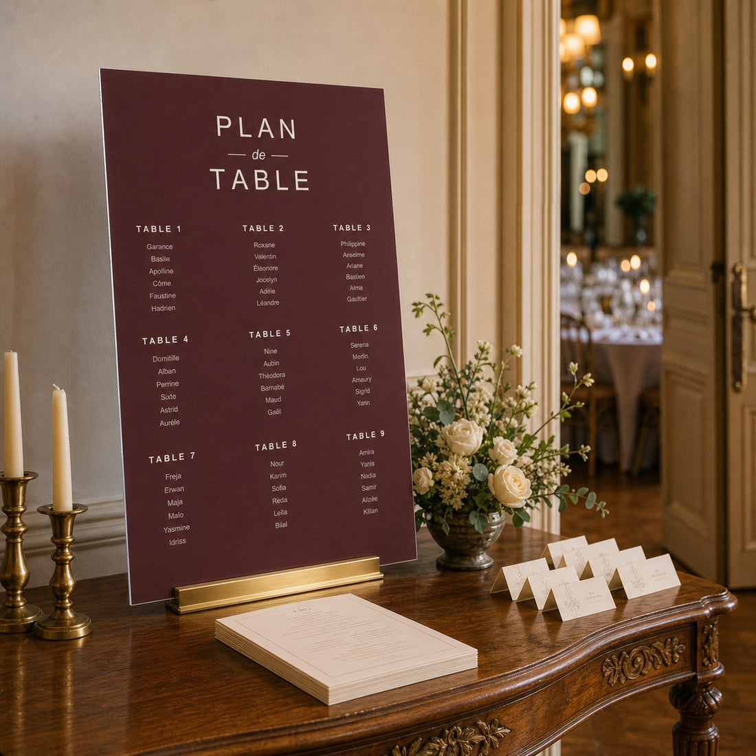 Tableau dei tavoli per matrimonio bordeaux su una consolle nella sala del ricevimento.